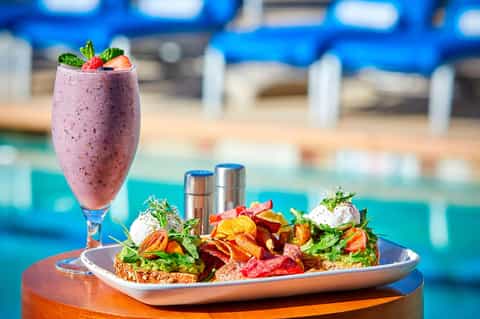 Gourmet salad and berry smoothie served poolside at resort restaurant