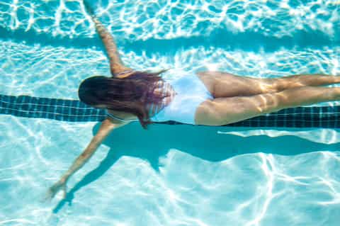 Female swimmer doing freestyle stroke in lap pool with lane marker