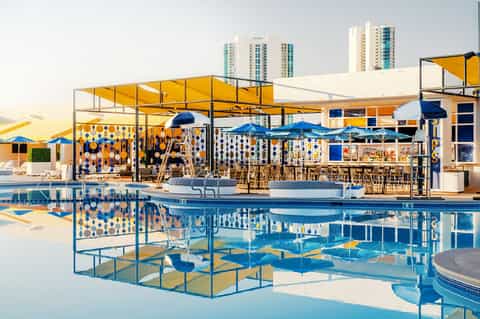 Modern rooftop pool bar with yellow umbrellas and colorful contemporary design
