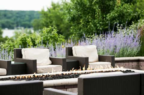 Fire pit with lounge chairs in garden setting with lavender plants