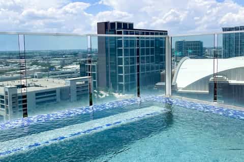 Infinity pool on high-rise rooftop overlooking cityscape and surrounding landscape