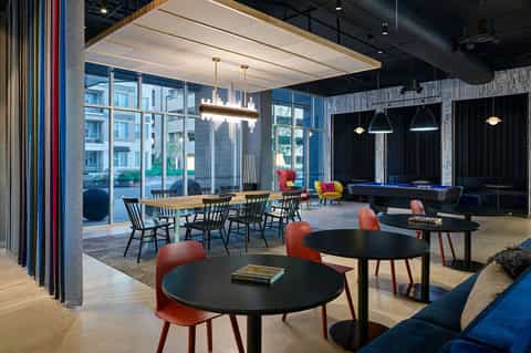 Modern hotel lounge with pool table, dining area, and contemporary furnishings