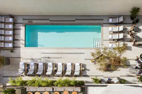 Overhead view of resort pool deck with turquoise pool, lounge chairs, and modern architecture