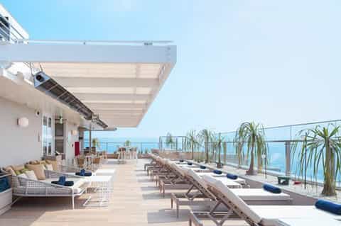 Oceanview resort terrace with lounge beds, retractable shade, and sea horizon views