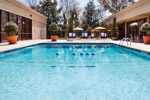 Olympic-style indoor swimming pool with lane dividers, lounge chairs, and modern facility design