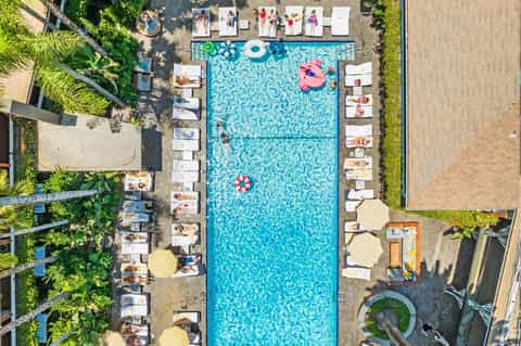 Aerial view of rectangular pool with turquoise water and white lounge chairs on surrounding deck