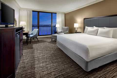 Luxury hotel room with king bed, balcony view, and modern furnishings