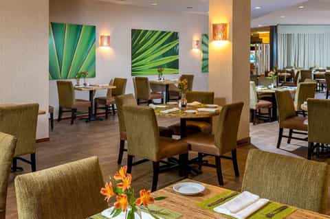 Contemporary restaurant dining area with green botanical wall art