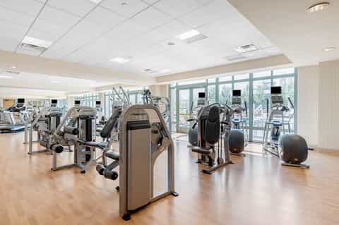 Bright fitness center with Nautilus exercise equipment and large windows overlooking grounds