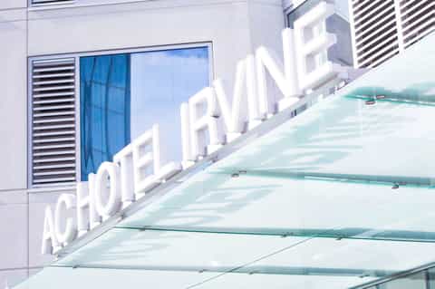Modern hotel building exterior with white 'Acormarine' signage and glass canopy