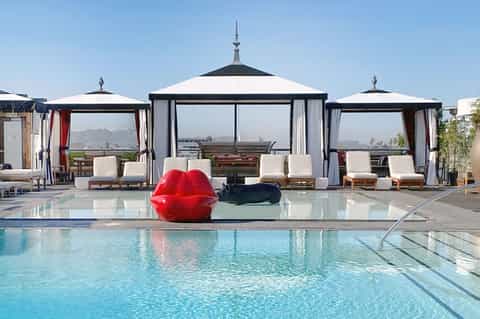 Luxury resort pool with black and white cabanas and red inflatable sculpture