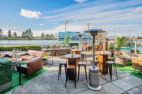 Upscale outdoor terrace with leather seating, firepit, and waterfront views