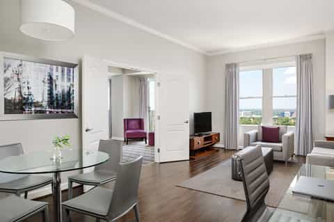 Spacious resort suite with living area, windows overlooking city, and elegant furnishings