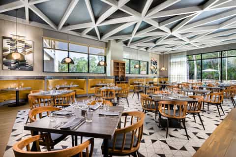 Modern dining room with geometric ceiling design and wooden furniture