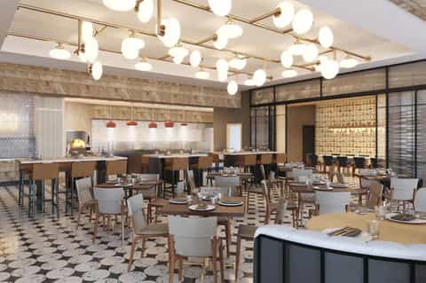 Contemporary restaurant dining room with patterned flooring, hanging globe lights, and open kitchen
