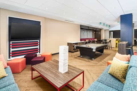 Recreation room with pool table, entertainment seating, and TV in contemporary hotel space