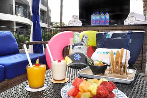 Beachfront cabana with colorful pillows, beverages, fresh fruit, and vibrant resort furnishings