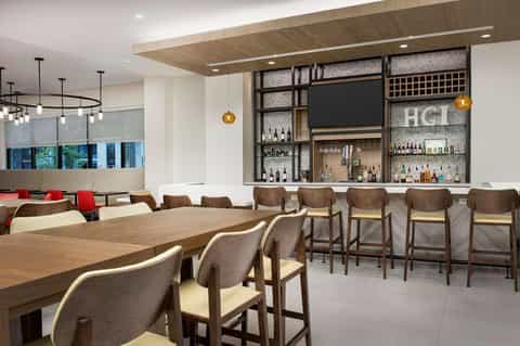 Modern hotel bar and lounge area with wooden tables and contemporary design