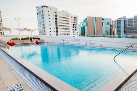 Indoor rooftop pool with city skyline and modern apartment buildings