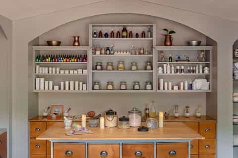 Wellness spa retail display with arched shelves holding colorful bottles, jars, and beauty products