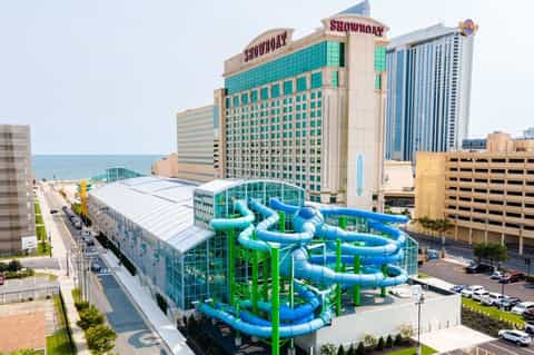 Beachfront water park with blue slide tubes and white covering adjacent to casino resort
