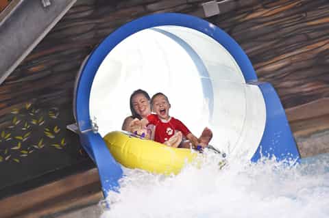 Family enjoying water slide at resort with splash splash effect
