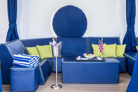 Blue luxury cabin interior with blue sofa, lime-green pillows, and circular window backdrop