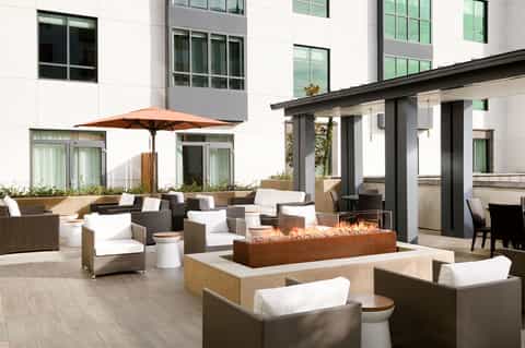 Modern patio with fireplace, comfortable seating, and contemporary architecture