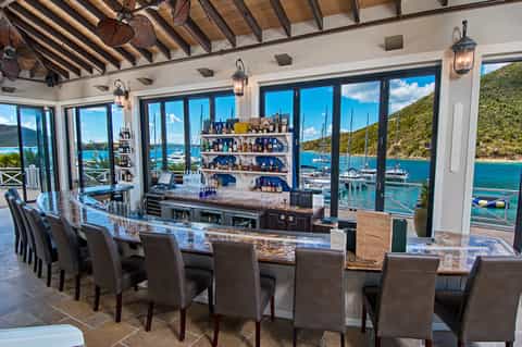Upscale bar overlooking marina with sailboats and mountain scenery