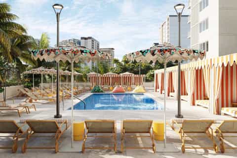 Colorful retro pool area with vintage carousel details, striped cabanas, and lounge chairs