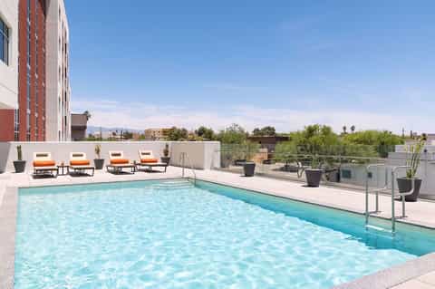 Rooftop pool deck with lounge chairs, mountain views, and desert landscape surroundings