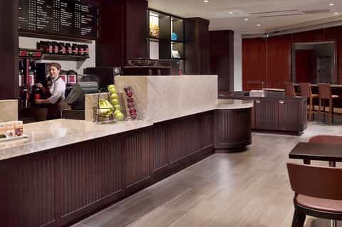 Upscale coffee shop counter with marble top and dark wood cabinetry