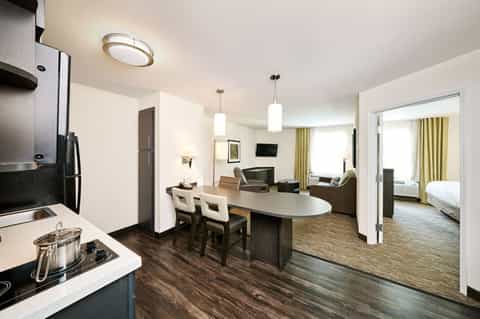 Spacious hotel suite with kitchen, dining area, living room, and bedroom visible