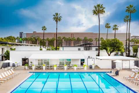 Olympic lap pool with lane dividers and modern resort facilities in background