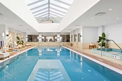 Indoor lap pool with skylights, lane dividers, and modern facility windows
