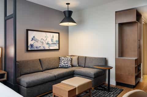 Modern hotel suite with gray sectional sofa and contemporary furnishings