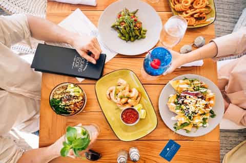 Overhead view of dining table with appetizers, drinks, and menu