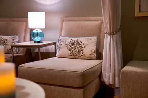 Elegant spa suite with upholstered headboard and soft ambient lighting