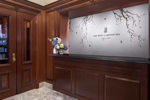 Ritz-Carlton Spa entrance with mahogany paneling, flowers, and elegant signage at Tysons Corner