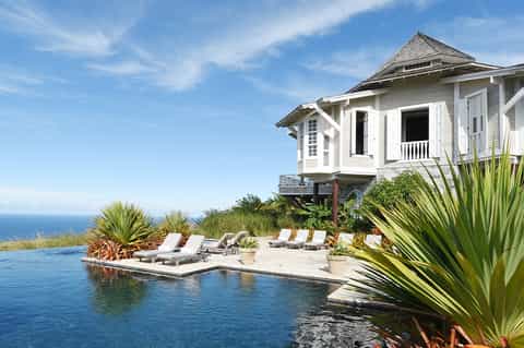 Luxury beachfront house with infinity pool, ocean view, and white modern architecture