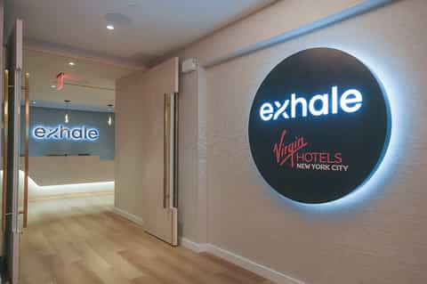 Exhale spa entrance at Virgin Hotels New York City with illuminated circular signage and modern hallway