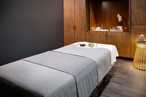 Luxury spa treatment room with massage beds, wooden cabinetry, and ambient lighting