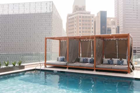 Rooftop pool with lounge cabanas and city skyline views