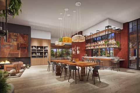 Modern dining area with wood furnishings, red accent walls, and pendant lighting
