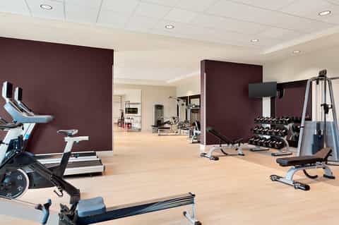 Modern fitness center with exercise bikes, weights, and gym equipment