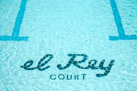 Le Parc Court pool bottom text visible in clear turquoise water with lane dividers