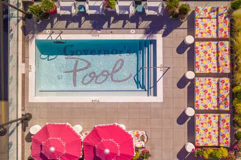 Overhead view of Governor's Pool with colorful umbrellas and lounge chairs on the surrounding deck