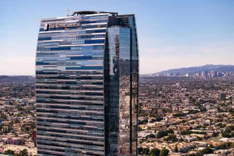 The Ritz-Carlton high-rise hotel building with blue glass facade overlooking Los Angeles cityscape