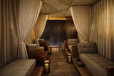 Elegant spa relaxation lounge with cream curtains, ambient lighting, and plush seating