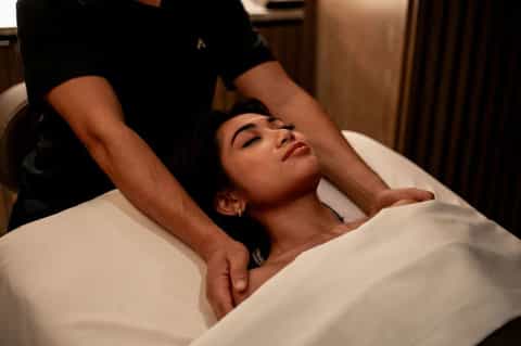 Woman receiving a relaxing spa massage treatment on a white massage table